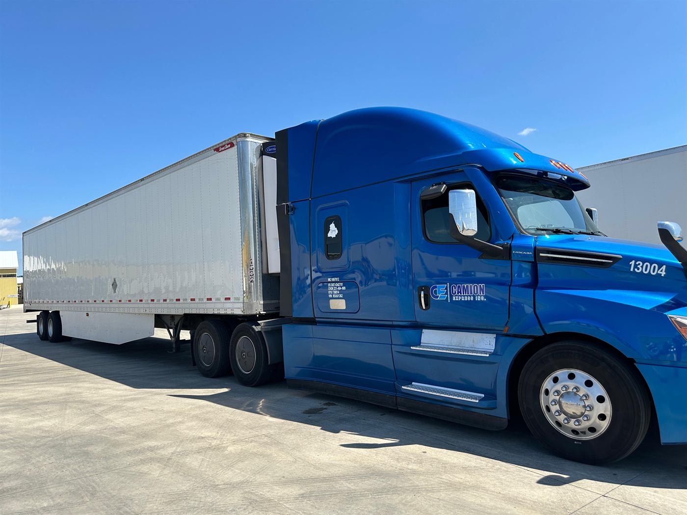 Side view of a blue Camion Express tractor pulling a 53-foot reefer trailer